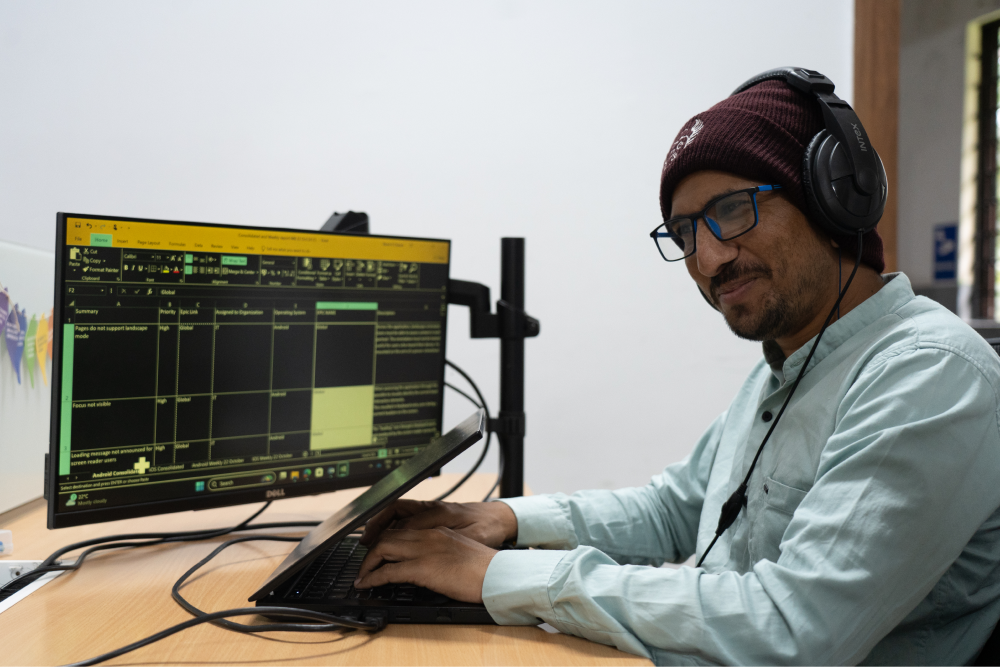 Person with visual disabilty using a laptop wearing a headphone